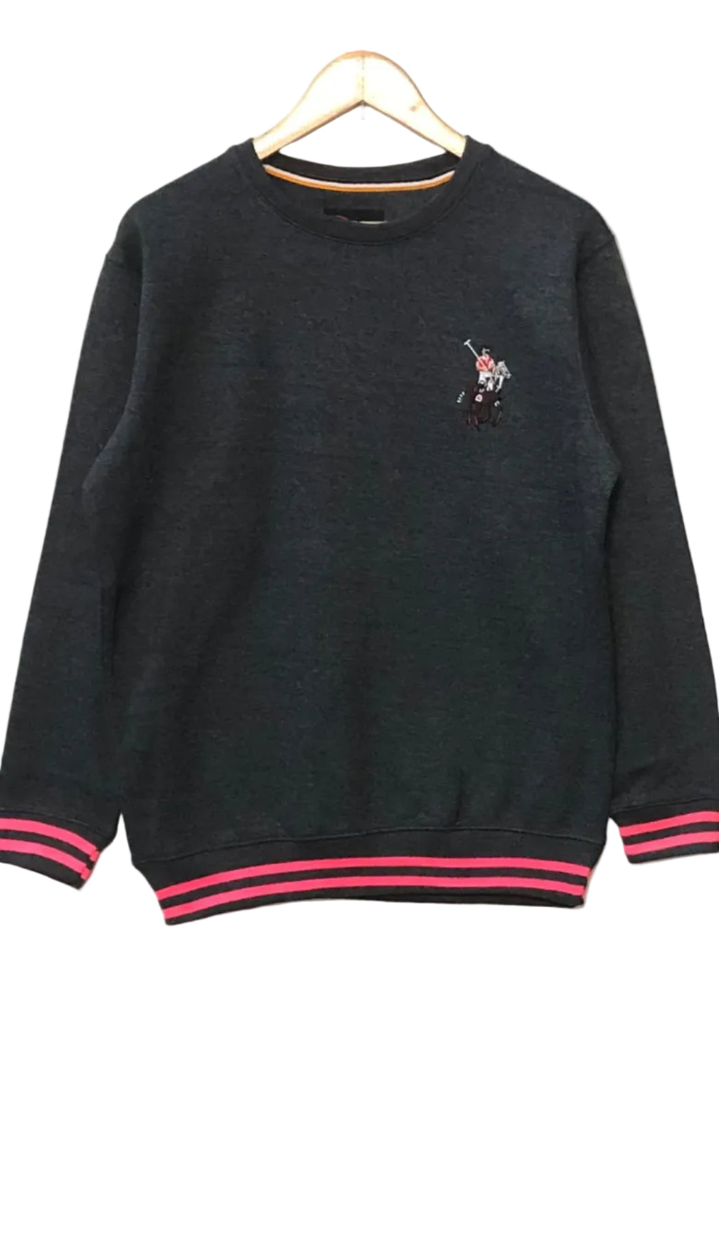 Charcoal sweatshirt with a small embroidered design on a hanger against a red and white wall.