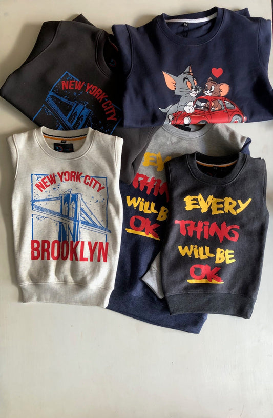 Four children's shirts with different designs on a light background